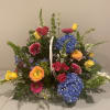 Basket arrangement with blue hydrangeas, roses, gerbera daisies, and yellow tulips