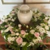 White and pink rose wreath around a ceramic urn
