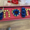 Decorative gift box with blue roses and chocolates arranged in letters