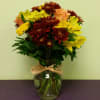 Bouquet of yellow and peach flowers in a glass vase