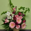 Pink and white mixed flower arrangement in a woven basket