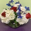 Red roses and white hydrangeas with blue flowers in a glass vase