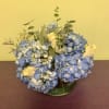 Blue hydrangea bouquet with white roses in a glass vase