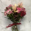 Bouquet of pink lilies, roses, and alstroemeria in a glass vase