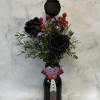 Black roses in a Halloween vampire vase with red berries