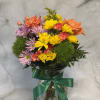 Mixed bouquet of orange roses, yellow daisies, and purple flowers in a glass vase