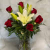 Red roses and white lilies arranged in a clear glass vase