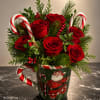 Deep red roses gathered in a festive ceramic mug make a bright