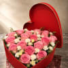 A lush cluster of pink roses and white daisy-like blooms arranged in