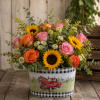 Mixed bouquet of roses and sunflowers in a decorative tin container
