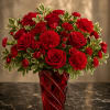 Red roses and carnations in a red glass vase
