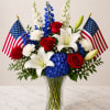 Bold red roses, white lilies, and sky-blue hydrangeas come together in a