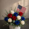 A low, proud cluster of red, white, and blue roses creates an
