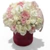 Pink and white roses arranged in a burgundy hatbox