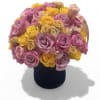 Bouquet of pink and yellow roses in a black hat box
