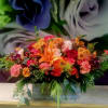 Colorful floral arrangement with lilies, roses, and mums in a wooden box