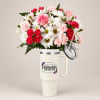 Bouquet of pink roses, carnations, and white daisies in a handled tumbler cup