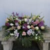 Large floral arrangement with pink and white roses, lilies, and purple blooms