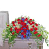 Red roses, blue flowers, and white blooms arranged on a casket