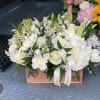 White floral arrangement in a wooden box with ribbon