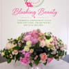 Pink and white floral arrangement in a clear pedestal vase