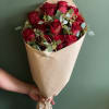 Hand-tied bouquet of red roses wrapped in brown paper