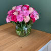 Pink and white roses arranged in a clear glass vase