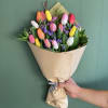 Bouquet of multicolored tulips wrapped in brown paper