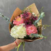 Pink peonies and white hydrangea bouquet with eucalyptus in brown paper