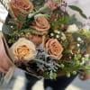 Bouquet of peach roses with small pink and white filler flowers