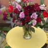An elegant arrangement in a glass vase, with  roses, cymbidium, snap