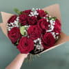 Bouquet of red roses with white baby's breath in brown paper