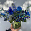 Arrangement in glass vase with shades of blues, that include hydrengea, orchid