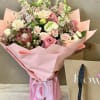 Pink bouquet with roses and mixed blooms wrapped in pink paper