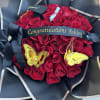Red rose bouquet with a graduation cap and black ribbon reading Congratulations Ashley
