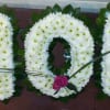 White floral letters spelling MOM with pink roses accenting the design