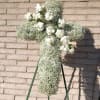White floral cross on a stand with small white roses