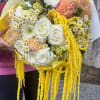 Large bouquet of white, peach, and yellow flowers with cascading yellow strands