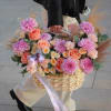 Basket of pink and peach flowers with a lavender ribbon
