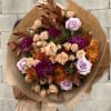 Large bouquet of roses and chrysanthemums wrapped in brown paper