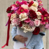 Large bouquet of red, pink, and cream roses in a white hatbox
