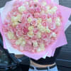 Large bouquet of pink and cream roses wrapped in pink paper