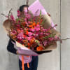 Large bouquet of pink and orange flowers wrapped in paper