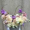 Bouquet of cream and lavender flowers in a gray vase