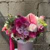 Pink and white bouquet in a pale pink hatbox with a ribbon.