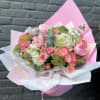 Pink and white bouquet of roses and hydrangeas wrapped in pastel paper