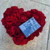 Heart-shaped bouquet of red roses with a small photo card on top