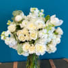 White roses and ranunculus in a clear glass vase