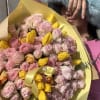 Pink and yellow bouquet wrapped in yellow paper
