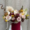 Mixed roses and small blooms in a burgundy hatbox with ribbon
